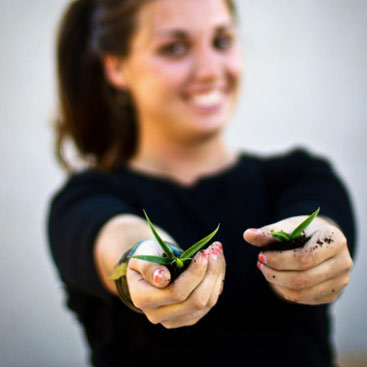 Girl holding plants out in her hands